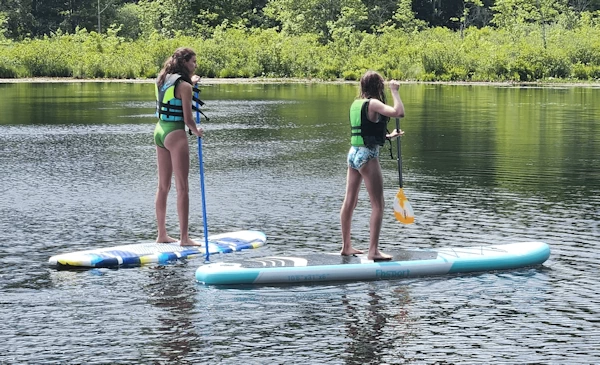2 teenagers paddleboarding in Connecticut